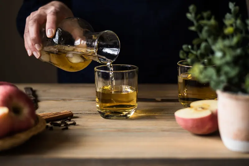 Cidre doré versé dans des verres, avec des pommes coupées