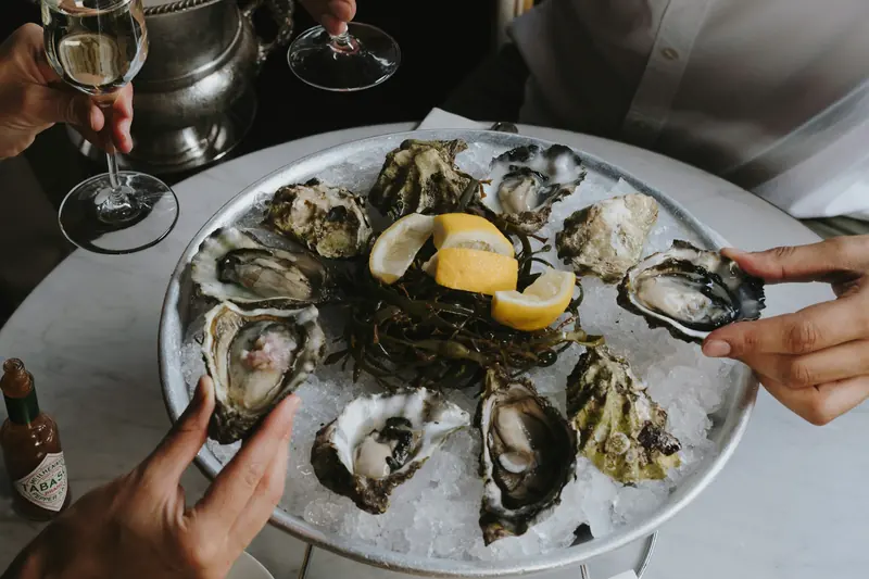 Huîtres sur glace et coupes de champagne partagées autour d’une table